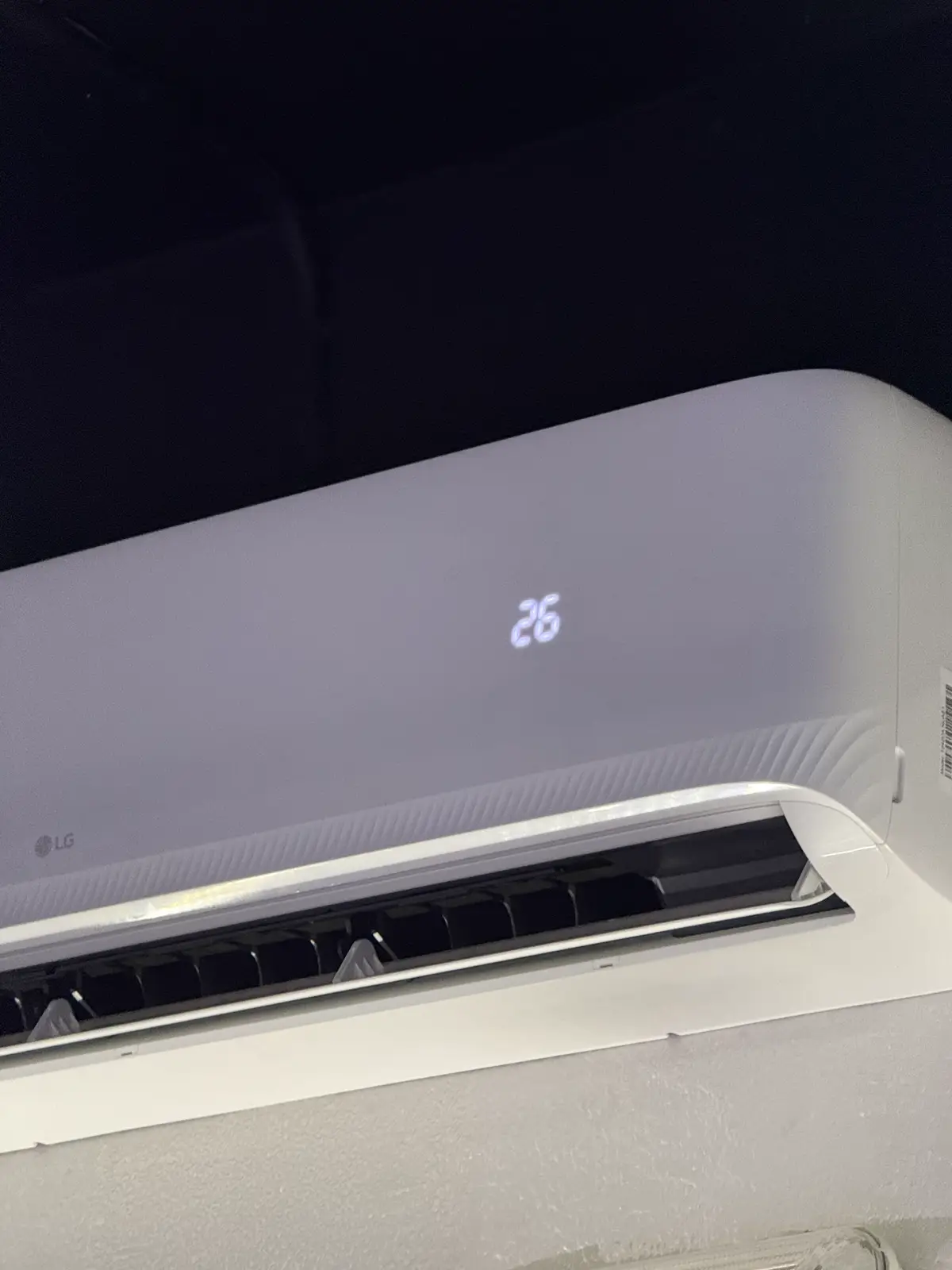 The LG split unit on the garage wall, set to 26 °C